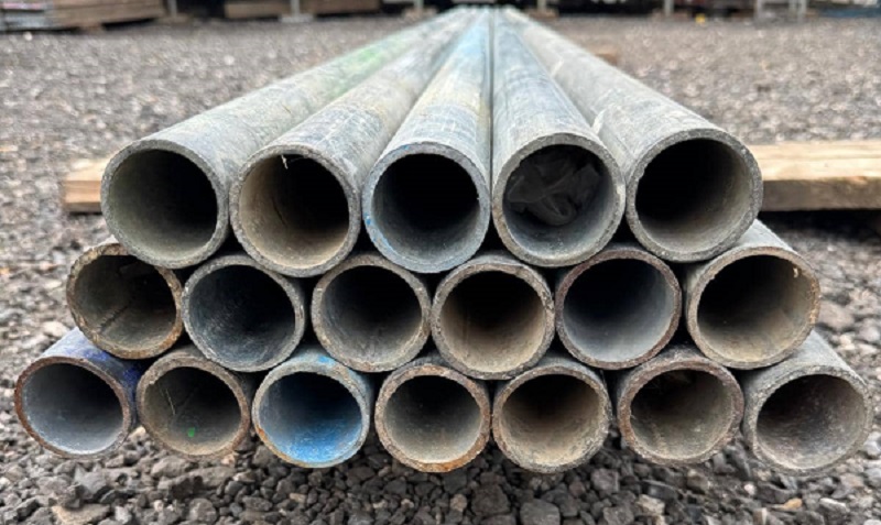 Stack of used galvanised scaffolding tubes in various lengths from 5ft to 21ft, available for sale at London Scaffolding Supplies